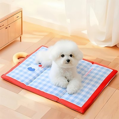 Tapis-rafraîchissant-chien-chiot-sans réfrigérateur-sans eau-sans électricité -sans gel toxique-un petit chien au frais couché sur son tapis bleu à carreaux vichy sur le sol du salon