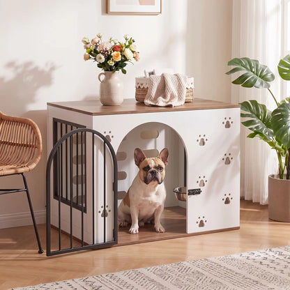 Cage-pour-chien-maison-chiot-niche en bois blanc et bois naturel design avec pattes de chiens sculptées sur les facades avant, facade arrière en bois avec grandes ouverture pour un effet ouvert sécurisant et aérée, grille sur le côté gauche et porte avant en barreaux acier noir inoxydable et ultra résistante avec serrure à loquet coulissant noir et côté droit en bois pour chiot et chien de 0-20 kg-un bouledogue français assis confortablement dans la cage, porte grille ouverte en meuble d'appoint