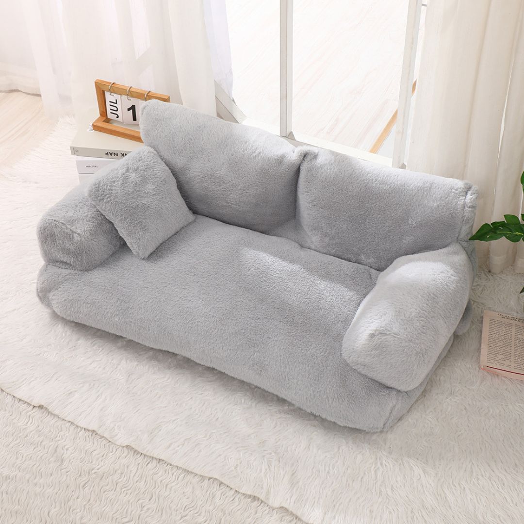 Canape pour chien et chiot de grande taille xxl de couleur gris foncé ou gris clair, déhoussable et lavable en mùachine, housse douce en peluche courte avec dossier et accoudoirs au rembourrage 100% coton PP ergonomique pour un soutien optimal-gros plan sur le canapé pour chien de couleur gris clair en peluche douce au toucher velours dans le salon de la maison