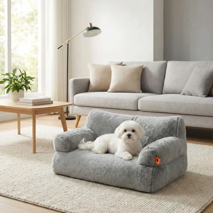 Canapé-petit-chien-douillet-anti-poils-déhoussable et lavable en machine-housse en peluche ultra-douce avec fond antidérapant et imperméable avec accoudoirs cylindrique dossier et assise au rembourrage 100% coton haute densité, ergonomique et 4 saisons, respirant et chaud-un Coton de Tuléar confortablement couché sur le canapé pour chien gris au toucher velours dans le salon de l'appartement