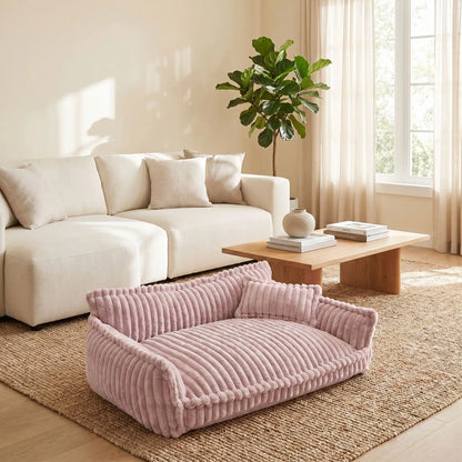 Canapé-pour-chien-chiot-déhoussable, lavable en machine, housse en velours douce comme un lit en peluche, avec accoudoirs et dossier entourant au rembourrage 100% coton PP avec un oreiller lavable en velours assorti pour chien de 0 à + de 45kg, antidérapant et fond imperméable-gros plan sur le  le grand canapé xxl de 120 cm de long en velours de couleur mauve dans le salon de la maison