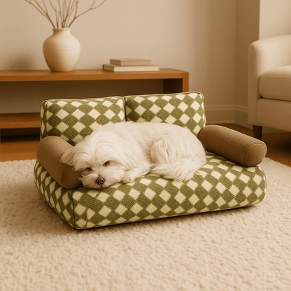 Canapé-pour-chien-douillet en velours-déhoussable et lavable en machine-antidérapant-avec dossier et accoudoirs cylindriques au rembourrage 100% Coton haute densité ergonomique, hypoallergénique au design rétro à carreaux pour petit à chien de moyenne taille de 0 à 20 kg-un Bichon Maltais qui dort paisiblement sur son canapé en losange vert et beige avec accoudoirs marron dans le salon de l'appartement