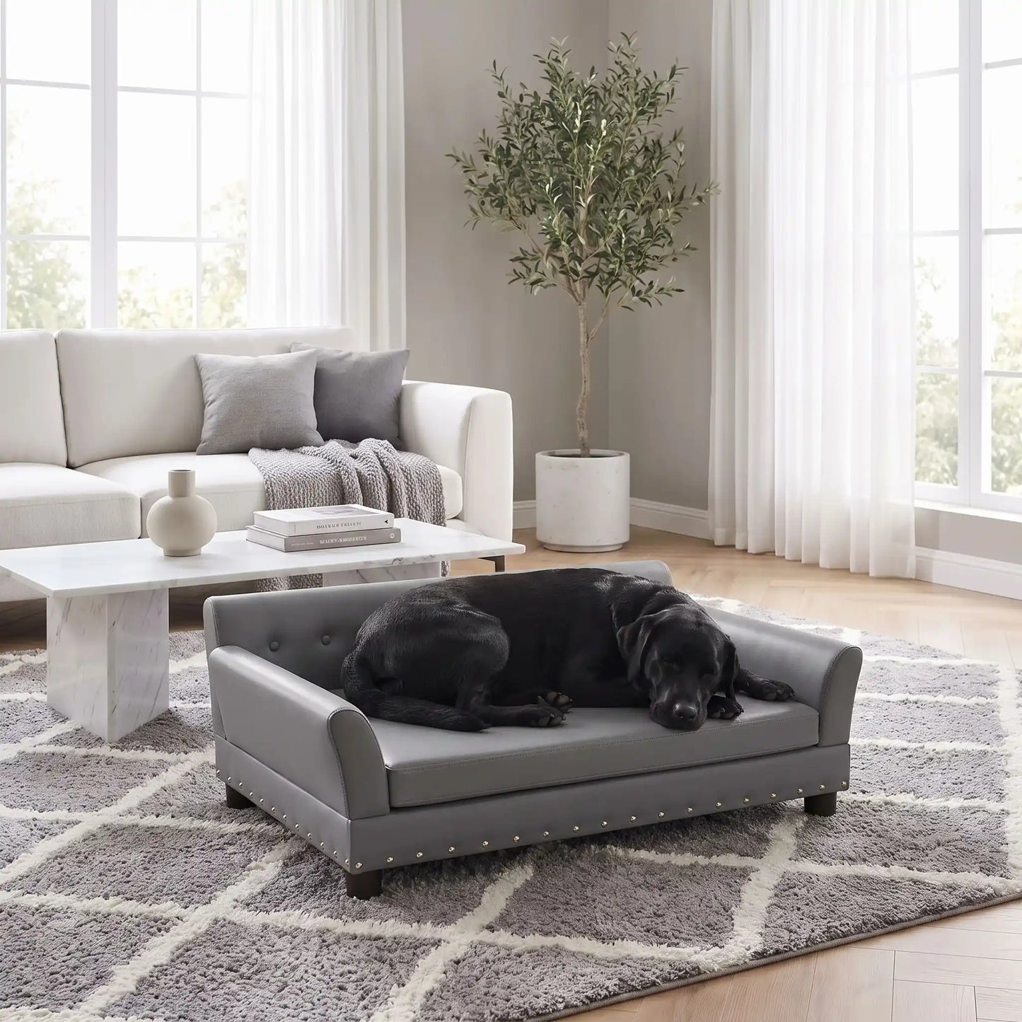 Canapé-pour-chien-xxl-120-cm-matelas orthopédique à mémoire de forme en coton PP épais déhoussable, 100% imperméable et résistant aux griffes en cuir PU sur 4 pieds en bois et structure robuste en bois d'eucalyptus robuste avec une capacité de charge de 100 kg pour chien de moyenne à grande taille de couleur gris foncé- un chien de grande race qui dort couché confortablement sur le canapé design en bois avec accoudoir et matelassé avec matelas amovible orthopédique déhoussable et lavable dans le salon 