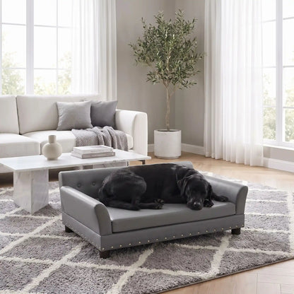 Canapé-pour-chien-xxl-120-cm-matelas orthopédique à mémoire de forme en coton PP épais déhoussable, 100% imperméable et résistant aux griffes en cuir PU sur 4 pieds en bois et structure robuste en bois d'eucalyptus robuste avec une capacité de charge de 100 kg pour chien de moyenne à grande taille de couleur gris foncé- un chien de grande race qui dort couché confortablement sur le canapé design en bois avec accoudoir et matelassé avec matelas amovible orthopédique déhoussable et lavable dans le salon 