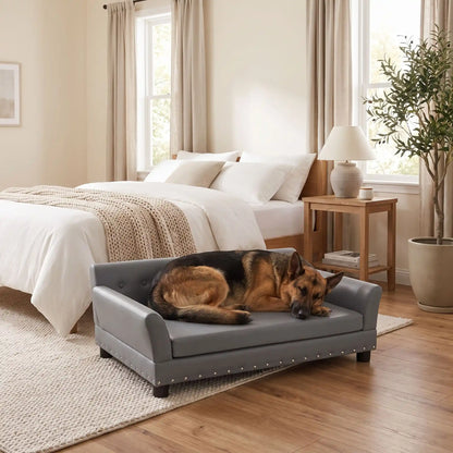 Canapé-pour-chien-xxl-120-cm-matelas orthopédique à mémoire de forme en coton PP épais déhoussable, 100% imperméable et résistant aux griffes en cuir PU sur 4 pieds en bois et structure robuste en bois d'eucalyptus robuste avec une capacité de charge de 100 kg pour chien de moyenne à grande taille de couleur gris foncé- un grand chien couché confortablement sur le canapé design en bois avec accoudoir et matelassé avec matelas amovible orthopédique déhoussable et lavable dans la chambre de la maison