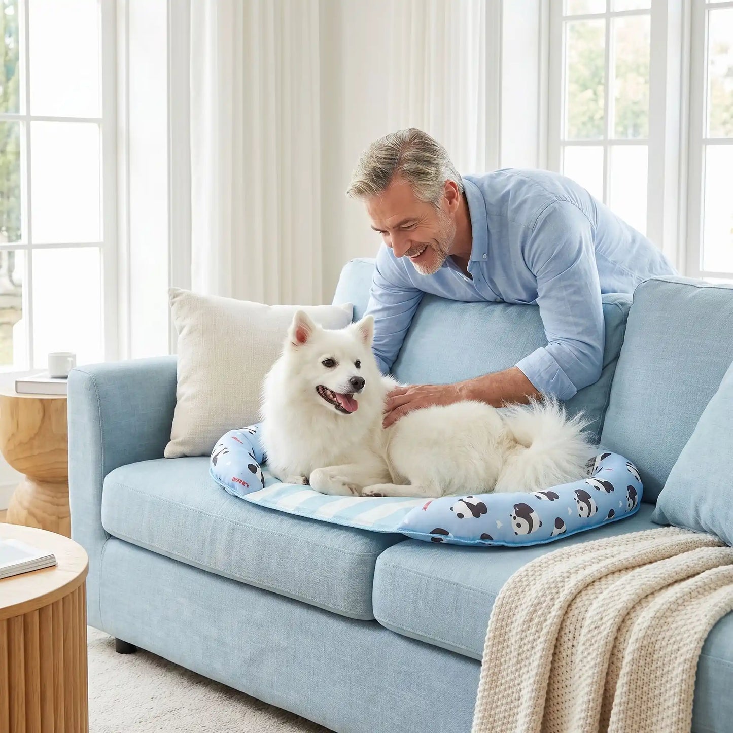 Chien-tapis-rafraichissant-coussin-apaisant avec rebord surélevé en U pour un effet entourant 100% coton haute densité, respirant , lavable et antidérapant, un effet rafraichissant immédiat sans eau ni électricité, sans danger pour les chiens de petites à moyenne tailles-un chien de taille moyennne à poils longs couché confortablement sur son tapis rafraichissant sur le lit, entouré par le traversin rembourré protecteur, sur le canapé du salon, caressé par son maitre avec amour dans le salon en été