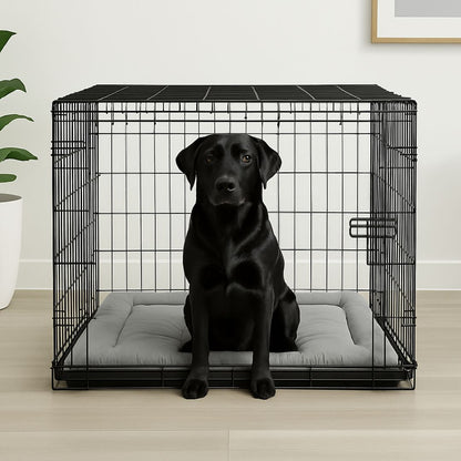 Coussin-pour-chien-XXL-rafraichissant-tapis rafraichissant et épais rembourrage 100% coton densité-un labrador noir assis dans sa cage sur le matelas gris