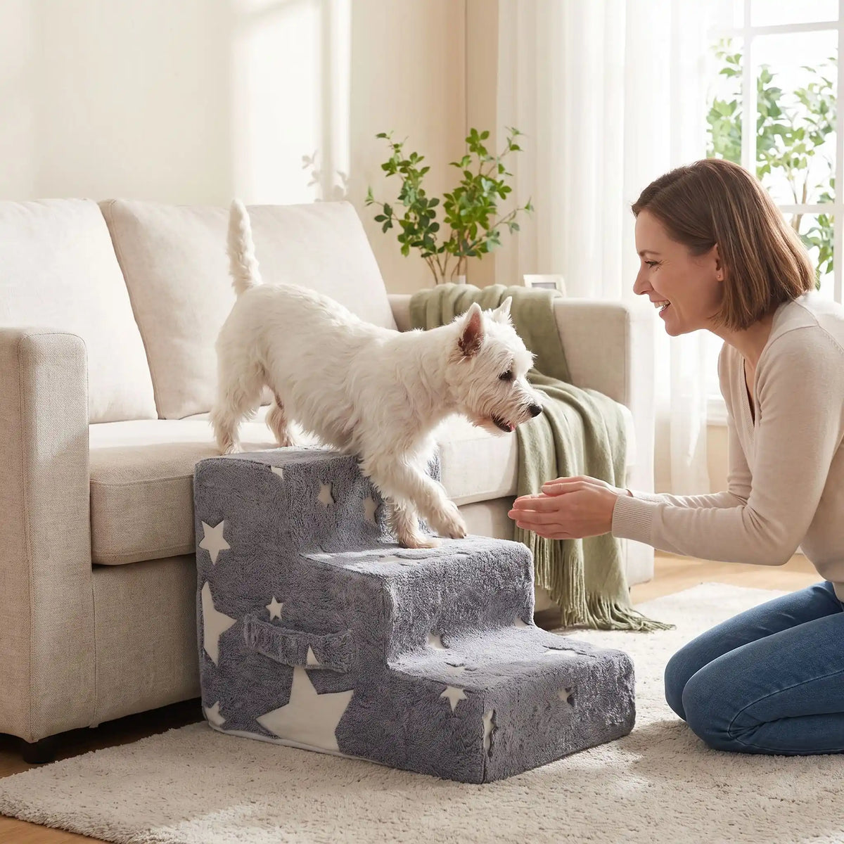 Escalier-mousse-pour-chien, chiot antidérapant, déhoussable lavable en machine avec mousse haute résilience à mémoire de forme pour protèger les articulations sensibles, sécurisé , confortable, résistant aux griffes pour petit et chien de moyenne taille-housse en velours ultra-douce avec motif étoiles phosphorescent pour la nuit -un chien qui descend du canapé par l'escalier de 3 marches en mousse pour rejoindre en toute sécurité sa maitresse assise au sol qui l'encourage en ouvrant les bras dans le salon
