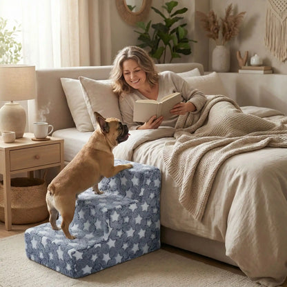 Escalier pour chien et chiot antidérapant, déhoussable lavable en machine avec mousse haute résilience à mémoire de forme pour protèger les articulations sensibles, sécurisé , confortable, résistant aux griffes pour petit et chien de moyenne taille-design velours sur le dessus ultra-doux et tissu en coton solide avec design étoiles-un chien de taille moyenne et âgé qui monte confortablement sur l'escalier de 4 marches en mousse pour rejoindre en toute sécurité sa maitresse qui l'attend dans son lit 