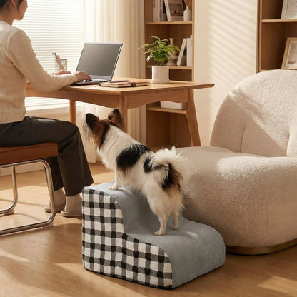 Escaliers-pour_chien-chiot-antidérapant, déhoussable lavable en machine avec mousse haute résilience à mémoire de forme pour protèger les articulations sensibles, sécurisé , confortable, résistant aux griffes pour petit et chien de moyenne taille-design velours sur le dessus ultra-doux et tissu en coton solide, style damier noir et blanc-un Epagneul papillon qsur les marches de l'escalier de 2 marches collé au fauteuil et à coté de sa maitresse qui travaille dans son bureau