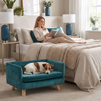 Fauteuil-pour-petit-chien-chiot-cocon- de petite taille de 0 à 8 kilos, structure en bois avec 4 pieds de bouleau robuste, dossier et accoudoir en U design nordique , 100 coton, toucher velours quadrillé pour un effet chic, matelas d'assise rectangulaire amovible en mousse 100% coton haute densité ergonomqiue déhoussable et lavable en machine, imperméable et résistant aux griffes-un chien de petite taille couché confortablement sur son petit fauteuil design de couleur bleu canard surélevé dans la chambre 