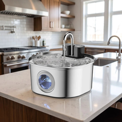 Fontaine-à-eau-chien-distributeur-automatique-inox 304D avec robinet verseur, avec batterie longue durée, rechargeable par USB, sans fil transportable, capacité de 3,2 litres, avec capteur de mouvement, 3 programmes : eau en continue, intermitence ou automatique avec filtre à 3 niveaux (charbon, coton, ions et éponge) design hublot sur le devant pour voir le niveau d'eau-gros plan sur la fontaine à eau automatique pour chiot et chien de petite à moyenne taille sur le plan de la cuisine 