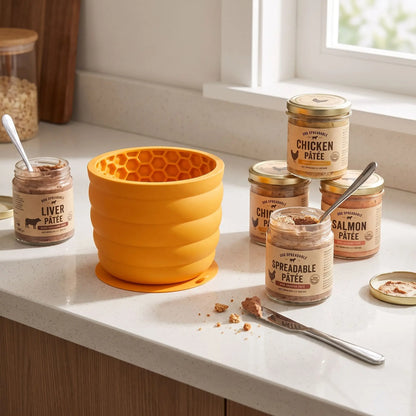 Gamelle-anti-glouton-chien-léchage-en silicone de qualtié alimentaire sans BPA, intérieur conception nid d'abeille avec ventouse intégrale ultra robuste pour le coller partout (mur, sol)  forme haute, idéal pour les races à longues oreilles, compatible lave-vaisselle, firgo et congélateur pour des préparations à lécher diverses, 2 taille S et L pour chiot et chien , contenance de 550ml à 1 litre-gros plan sur la gamelle anti-glouton jaune à côté de boite de pâté à tartiner pour chien dans la cuisine