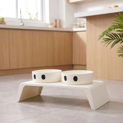 Gamelle-chien-surélevée-chiot-design de couleur blanc épuré de 8,5 cm de hauteur avec ses deux gamelles en inox amovibles lavable en lave-vaisselle avec pieds antidérapants, adapté aux chiots et chiens de petite race ou petite taille- gros plan sur la station d'alimentation pour chiot et chien avec son support design moderne blanc et ses deux gamelles blanches intégrée sur le sol de la cuisine de l'appartement