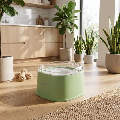 Gamelle-eau-chien-anti-eclaboussure-chiot-anti-bave avec base flottante et rebord surélevé anti projection, en plastique PP robuste de qualité alimentaire sans BPA, lavable en lave-vaisselle, démontable en 3 parties, garde l'eau propre et hygiénique et les babines de chien et les sols de la maison secs, grande capacité de 2 litres en 3 couleurs : blanc, vert et noir-gros plan sur la gamelle d'eau anti éclaboussure de couleur vert clair avec rebord et base surélevés design sur le sol en parquet du salon 