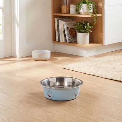 Gamelle-pour-chien-inox-3-tailles robuste et indéformable pour chien et chiot design hygiénique, lavable en lave-vaisselle avec son fond antidérapant en silicone pour une stabilité à toute épreuve, anti renversement, anti éclaboussures, design noir avec des patte de chien, en rose, bleu ou jaune disponible en 3 tailles 250/500/850 ml pour race de chiot ou chien de petite à moyenne taille-gros plan sur la gamelle bleue hygiénique pour chiot et chien avec fond antidérapant sur le sol en parquet du studio