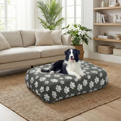 Housse-de-coussin-pour-chien-adaptable et universelle pour couchage, lit, cage pour chien en coton et polaire hypoallergénique douce et design pattes de chien mignon-housse avec élastique solide, de protection ultra douce, imperméable et hypoallergénique-disponible en 2 tailles L et XL, lavable en machine, résistante au griffes et aux chiens qui aiment creuser-un chien de taille moyenne à poils longs couché confortablement sur la housse qui enveloppe son matelas rectangulaire  dans le salon de la maison
