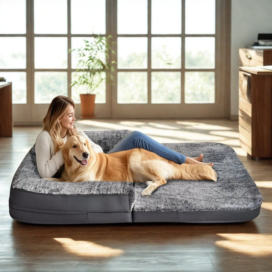 Lit-canape-pour-chien-lavable-cuir PU résistant aux griffe et morsure avec matelas à mémoire de forme déhoussable et lavable en machine avec dessus en peluche douce et hypoallergénique-une femme souriante avec son golden, allongée avec lui dans le lit canapé xxl pour un moment câlin et complice dans le salon de la maison