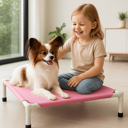 Lit-de-camp-chien-sur pied-en acier-respirant-résistant aux griffes-lavable en machine-transportable-démontable sans outils-pliable-multifonction-lit-surélevé pour petit chien et chiot-de couleur rose-petit chien couché sur son petit lit surélevé avec une petite fille assise à côté de lui dans le salonde la maison