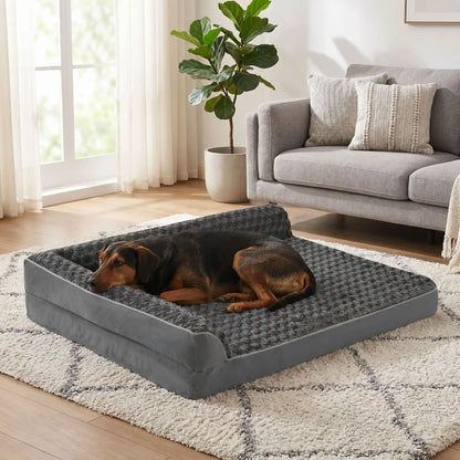 Lit-grand-chien-chiot-orthopédique-xxl avec traversin intégré,antidérapant-imperméable-déhoussable-lavable en machine-résistant aux griffes et morsures  pour grand chien et chiot jusqu'à 50 kg max-en velours côtelé et 100% Coton PP et deux traversins cylindriques rembourré en forme de L de couleur gris pour un effet apaisant et sécurisant-un Pinscher qui dort paisiblement niché dans l'angle du lit orthopédique , sa tête reposant sur l'un des deux traversins en L surélevés du lit dans le salon de la maison