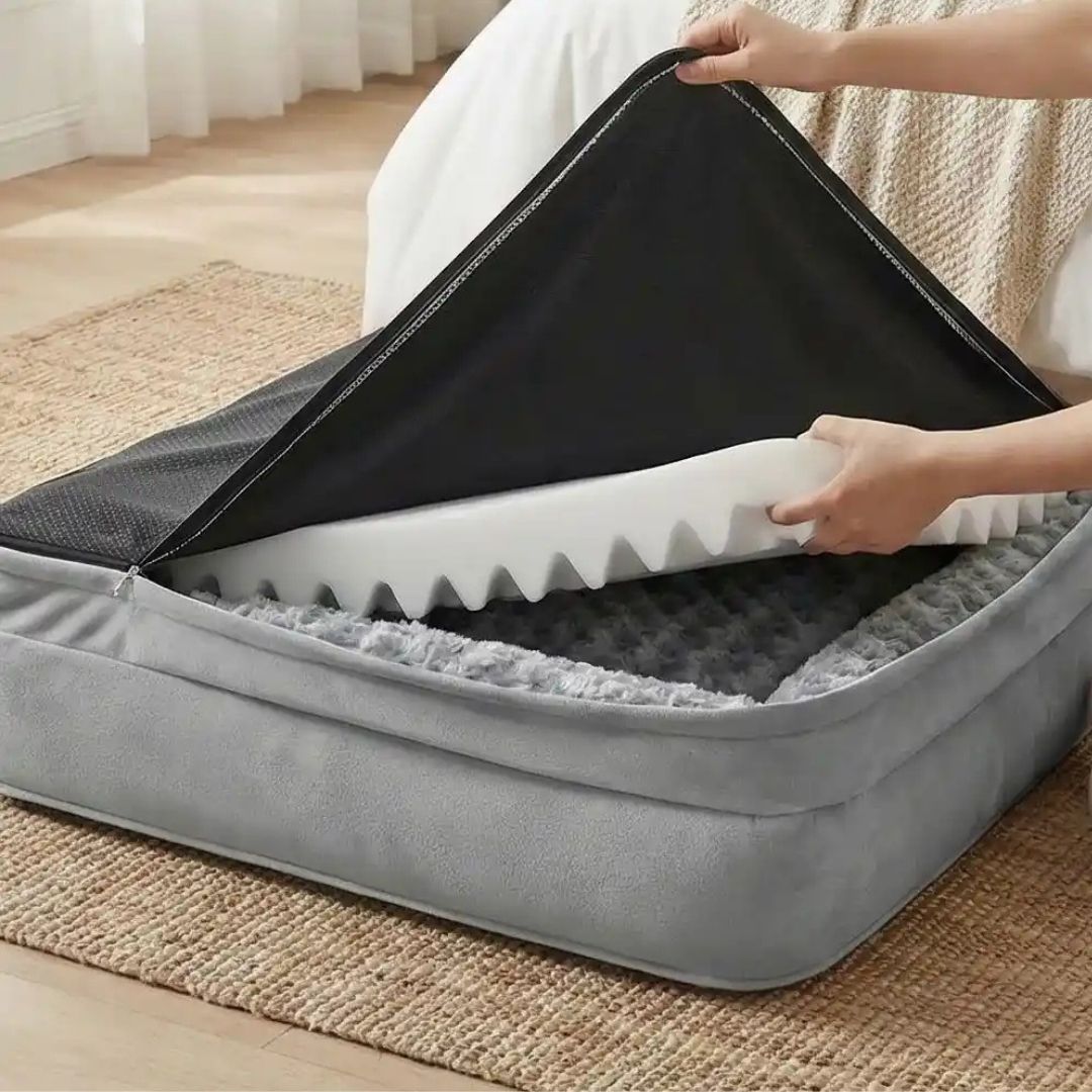 Lit-pour-chien-orthopédique-xl-antidérapant-imperméable-déhoussable-lavable en machine-résistant aux griffes et morsures légères pour grand chien et chiot jusqu'à 40 kg max-en velours côtelé et 100% Coton PP et deux traversin cylindriques rembourré en forme de L de couleur gris-un propiétaire de chien qui déhousse entièrement le lit pour chien avec son matelas en forme d'oeufs à mémoire de forme et sa housse antidérapante et imperméable pour laver à la machine