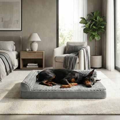 Lit-pour-chien-orthopédique-xl-antidérapant-imperméable-déhoussable-lavable en machine-résistant aux griffes et morsures légères pour grand chien et chiot jusqu'à 40 kg max-en velours côtelé et 100% Coton PP et deux traversin cylindriques rembourré en forme de L de couleur gris-un grand chien qui dort paisiblement sur son lit orthopédique, la tête reposant dans le coin du L des deux traversins dans la chambre de son maître de la maison