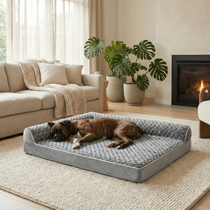 Lit-pour-chien-orthopédique-xl-antidérapant-imperméable-déhoussable-lavable en machine-résistant aux griffes et morsures légères pour grand chien et chiot jusqu'à 40 kg max-en velours côtelé et 100% Coton PP et deux traversin cylindriques rembourré en forme de L de couleur gris-un chien de taille moyenne qui dort paisiblement sur son lit orthopédique, la tête reposant dans le coin du L des deux traversins dans le salon de la maison