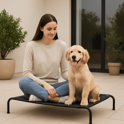Lit-pour-chien-surélevé-lit camp chien en maille aérée et respirante pour toute saison-hygiénique-imperméable-ergonomique flexible et structure en acier solide et pieds antidérapant de couleur noir-un maitre et son chiot assis côte à côte sur le lit hamac noir dans le jardin de la maison en été