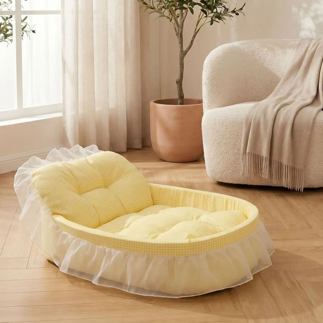 Lit-pour-chihuahua-4-saisons-avec son coussin interieur amovible épais et moelleux en mousse coton haute densité ergonomique, tissu respirant et lit lavable en machine avec design mignon en dentelle, entourant avec son rebord surélevé et sa décoration en dentelle, lit de princesse, couffin mignon-gros plan sur le lit en forme de couffin original et mignon avec sa dentelle et son coussin interieur rembourré pour un soutien ferme et moelleux à la fois de couleur jaune sur le sol du salon de l'appartement