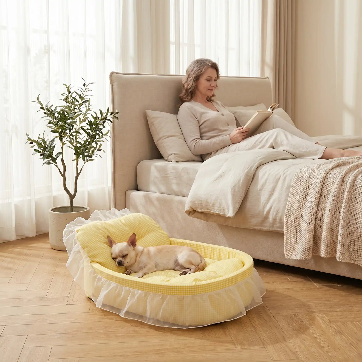 Lit-pour-chihuahua-4-saisons-avec son coussin interieur amovible épais et moelleux en mousse coton haute densité ergonomique, tissu respirant et lit lavable en machine avec design mignon en dentelle, entourant avec son rebord surélevé et sa décoration en dentelle, lit de princesse, couffin mignon-un chihuahua qui dort paisiblement niché dans son petit lit ovale anti stress de couleur jaune sur le sol à côté du lit de sa maitresse allongée qui lit son livre dans la chambre de l'appartement
