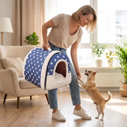 Niche chien et chiot intérieur de petite race, résistante, en forme d'igloo au design sécurisant fermée en arc de cercle avec un coussin rectangulaire au rembourrage 100% coton haute densité lavable,double face été en tissu/hiver en peluche  et fond antidérapant et extérieur 100% imperméable, transportable avec sa poignée, lavable- une maitresse qui porte la niche douillette, chaude sécurisante à 360° avec design américain bleu et étoiles blanches de son chien de race naine dans le salon de la maison