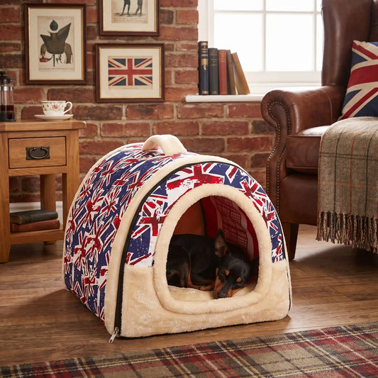 Niche chien et chiot intérieur de petite race, résistante, en forme d'igloo au design sécurisant fermée en arc de cercle avec un coussin rectangulaire au rembourrage 100% coton haute densité lavable,double face été en tissu/hiver en peluche  et fond antidérapant et extérieur 100% imperméable, transportable avec sa poignée, lavable- un chien de race naine qui dort couché confortablement au chaud dans sa niche douillette, chaude sécurisante à 360° avec design londonnien dans le salon de l'appartement