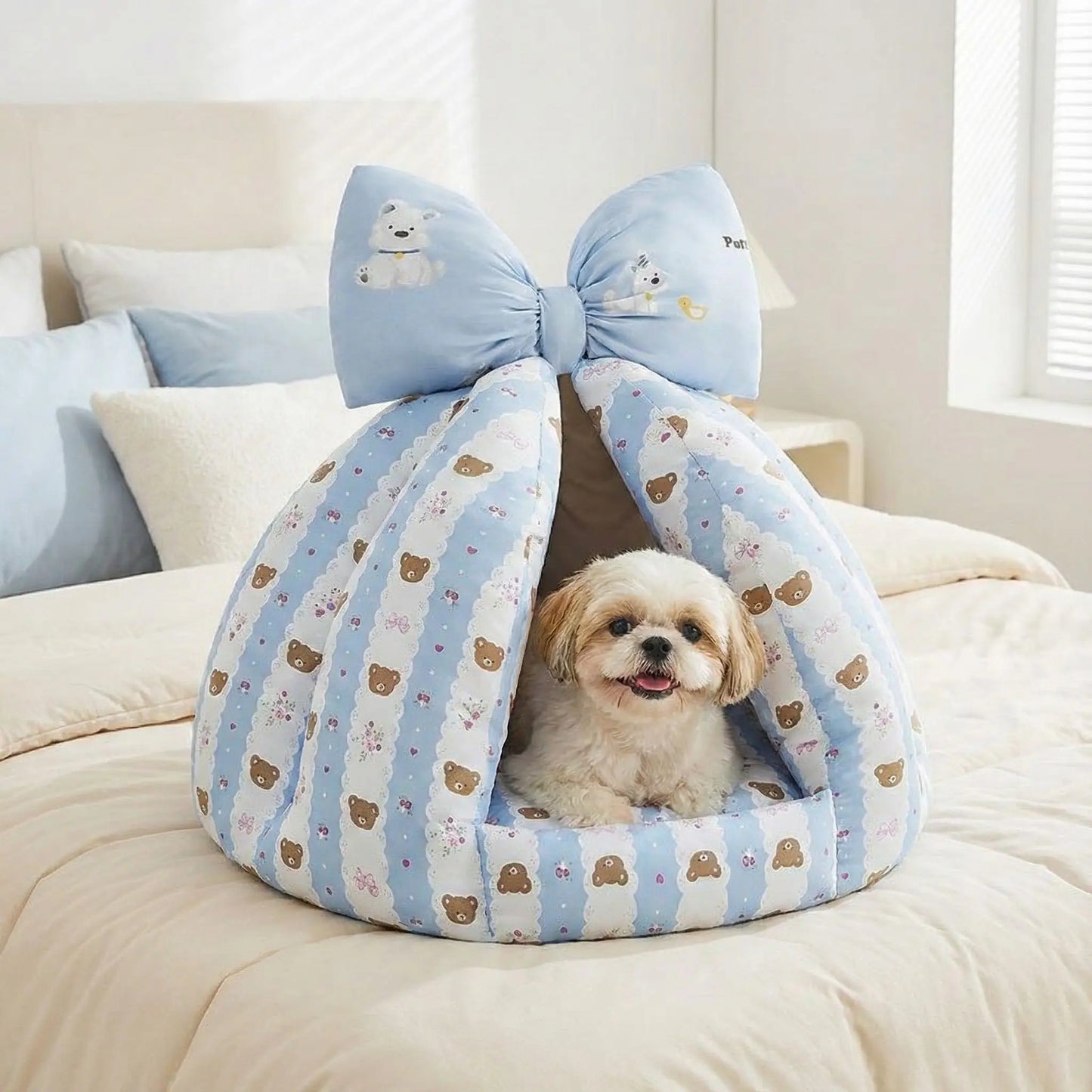 Niche-chien-interieur-coussin-apaisant-rembourrage et tissu 100% coton PP hypoallergénique et écoresponsable poiur petit chien et chiot de 0 à 8 kilos-coussin amovible et lavable en machine, antidérapant et fond imperméable-deux coloris disponible bleu et beige avec noeud décoratif sur le sommet-un Shih Tzu couché et heureux dans sa niche en forme de dôme chaud et respirant sur le lit de la chambre de la maison