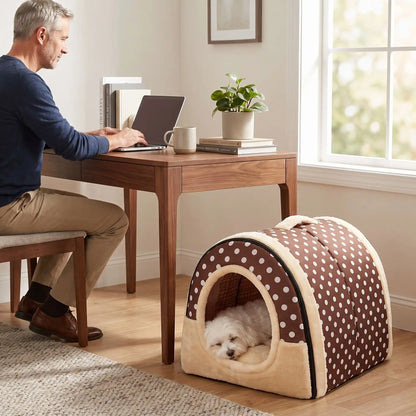 Niche chien et chiot intérieur de petite race, résistante, en forme d'igloo au design sécurisant fermée en arc de cercle avec un coussin rectangulaire au rembourrage 100% coton haute densité lavable,double face été en tissu/hiver en peluche  et fond antidérapant et extérieur 100% imperméable, transportable avec sa poignée, lavable- un chien petite race qui dort couché confortablement au chaud dans sa niche douillette, chaude sécurisante à 360° au pied du bureau de son maitre qui travaille sur l'ordinateur