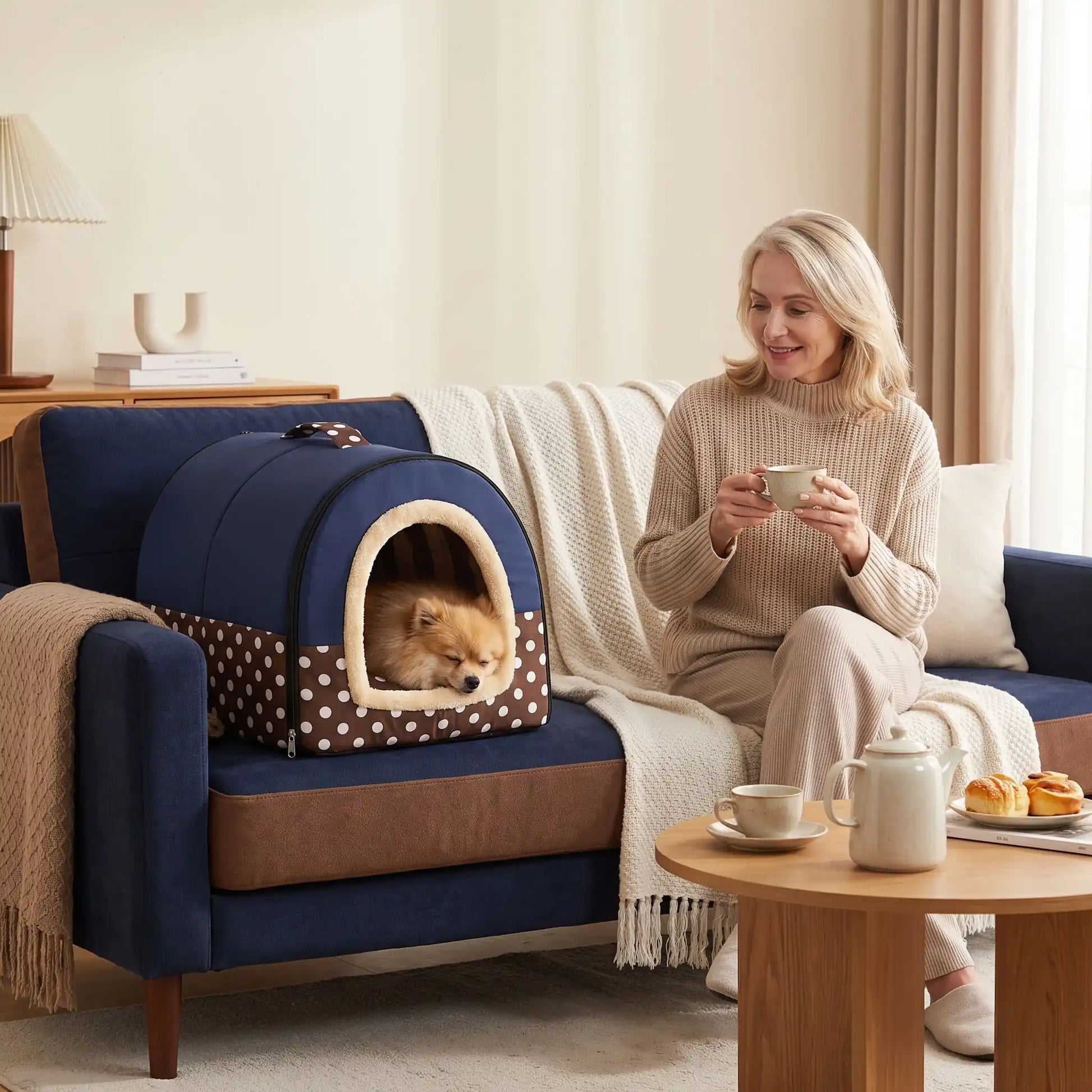 Niche chien et chiot intérieur de petite race, résistante, en forme d'igloo au design sécurisant fermée en arc de cercle avec un coussin rectangulaire au rembourrage 100% coton haute densité lavable,double face été en tissu/hiver en peluche  et fond antidérapant et extérieur 100% imperméable, transportable avec sa poignée, lavable- un chien race miniature qui dort paisiblement au chaud dans sa niche douillette, chaude sécurisante à 360° sur le canapé à côté de sa maitresse assise dans le salon de la maison