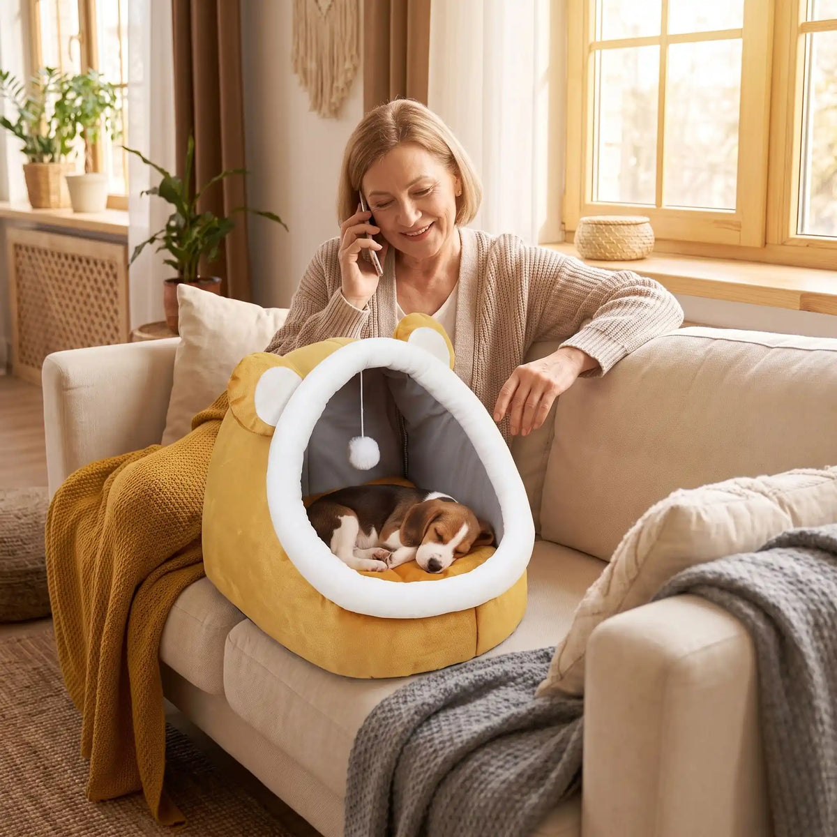 Panier-chien-chiot-niche-anti-stress, conception semie fermée avec toit et coussin amovible en velours rembourrage 100% coton PP, niche en peluche douce et design mignon avec oreilles d'ours, fond antidérapant et imperméable, lavable en machine pour chiot et chien de petite race de 0 à 3 kg-un chiot de race moyenne qui dort couché confortablement dans son panier avec toit en dôme comme une cabane en peluche douce sur le canapé à côté de sa maitresse assise dans le salon de la maison