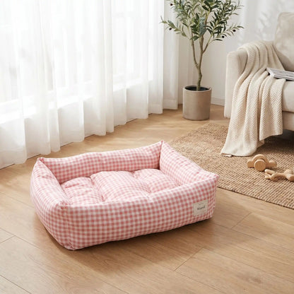 Panier chien et chiot rectangulaire avec rebord 360° surélevé en tissu pour chien de petite taille, 100% coton haute densité avec coussin intérieur amovible double-face été/hiver lavable en machine avec fond imperméable et antidérapant, design à carreaux vichy chic et frais pour un lit 4 saisons pour chien et chiot de 0 à 9 kilos-gros plan sur le panier rembourré et épais comme un coussin moelleux rectangulaire avec rebord surélevé 360° au design carreaux vichy de couleur rose sur le sol du salon 