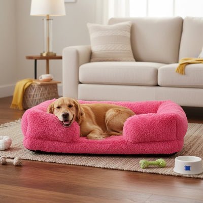 Panier-chien-xxl-déhoussable-orthopédique-coussin rectangulaire avec rebord surélevé en traversin qui sert d'oreiller ergonomique à 360° rembourrage 100% coton haute densité pour un effet anti stress et anti anxiété-housse en peluche ultra douce, hypoallergénique, imperméable, antidérapant et lavable en machine pour chiot et chien de taille moyenne à grande jusqu'à 45 kg max-un grand chien couché et heureux dans son lit rectangulaire avec rebord haut de couleur rose dans le salon de la maison