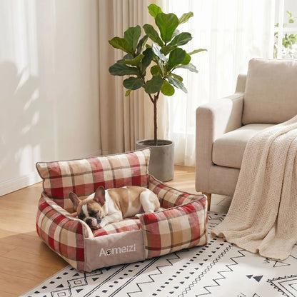 Panier-chiot-déhoussable-4-saisons, lavable en machine, housse en tissu respirant lin et coton, rembourrage 100% coton haute densité épais et ergonomique, coutures solides et résistant aux griffes et morsures, design ectangulaire avec dossier plus haut et épais que les rebords latéraux style canapé moelleux,  motif carreaux écossais pour chiot de 0 à 15 kilos-un chiot de race moyenne taille qui dort paisiblement dans son petit panier à motif à carreaux rouge et crème chic dans le salon de la maison