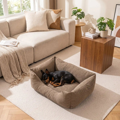 Panier- pour chien chiot entièrement déhoussable et lavable en machine, et 5 coussins ergonomiques 100% coton haute résilience à mémoire de forme, imperméable et antidérapant, avec rebords surélevés et housse  imperméable résistante aux griffes, intérieur en fausse fourrure de mouton hypoallergénique et ultra-doux, disponible en 3 tailles S, M, L pour chiot et chien de 0 à 60 kilos max-un chien race toy qui dort paisiblement niché dans son panier gris lavable taille S dans le salon de l'appartement