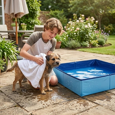 Pataugeoire-pour-chien-chiot-petite race, race toy et miniature, PVC renforcé, paroi rigide, pliable, compact, forme carré , fond antidérapant, résistante aux griffes, transportable, séchage rapide, anti-UV, en deux coloris bleu et rouge, pateaugeaoire pour les chiens plus grand-un chien de petite race tout mouillé qui sort de la pateaugoire de 50x50x10 cm avec bord rigide mouillé et son jeune maitre qui l'essuye doucement avec une serviette  ans le jardin de la maison en été