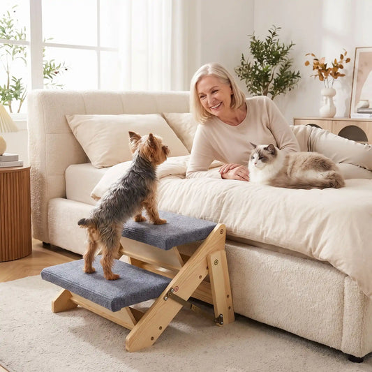 Petit-escalier-pour-chien-chiot pliable en bois de pin et tissu polyester doux et antidérapant résistant aux griffes-escabeau pour chien de 2 marches en bois naturel design our chiot et chien de petite à moyenne race, pliable, compact et léger de 2,7 kg facilement transportable-un chien de petite taille qui monte sur l'escalier pour rejoindre sa maitresse qui l'appelle allongée sur son lit dans la chambre de la maison