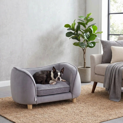 Petit-fauteuil-pour-chien-chiot-coussin intérieur épais au rembourrage 100% coton ergonomique, velours doux et résistant aux griffes, imperméable déhoussable et lavable en machine, de couleur gris, au design enveloppant en forme bateau structrure en bois massif avec 4 pieds à vissés en bois massif et robuste pour chiot et chien de petite taille à moyenne taille-un chien de  race moyenne qui dort paisiblement enveloppé dans son fauteuil avec son haut dossier arrondie en U en velours gris sur 4 pieds en bois 