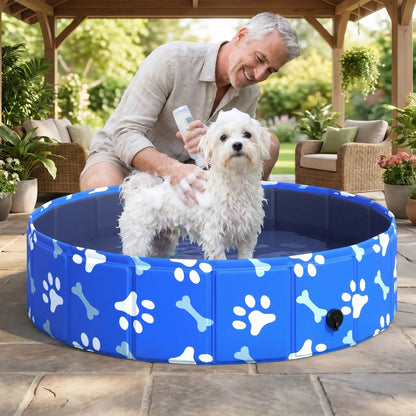 Piscine-rigide-pour-chien-rigide en panneaux MDF robuste anti-affaissement, pliable et lavable de diamètre 80 cm et de 20 cm de hauteur étudié pour une entrée et sortie facile et sécurisé pour le chien avec bouchon de vidange pratique et rapide, polyvalente piscine à balle, bassin, baignoire pour toilettage-un chien de petite taille qui se fait toiletter par son maitre qui met le shampoing sur son pelage sur la terrasse ombragée de la maison en été