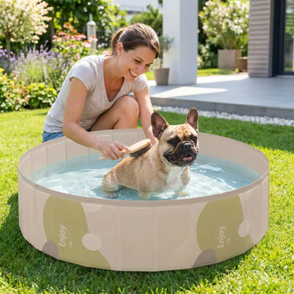 Piscines-pour-chiens-rigide en panneaux MDF robuste anti-affaissement, PVC sans produits toxiques , pliable et lavable de diamètre 80/100/120 cm et de 20/30 cm de hauteur étudié pour une entrée et sortie facile et sécurisé pour le chien avec bouchon de vidange pratique et rapide, polyvalente piscine à balle, bassin, baignoire pour toilettage-un petit chien qui se fait toiletter dans la piscine remplie d'eau  par sa maitresse souriante pour un moment complice maitre-chien dans le jardin du pavillon en été