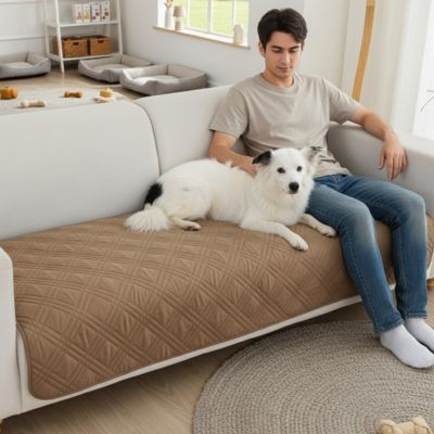 Protection-canape-chien-couverture-protege-siege-imperméable, résistant aux griffes, durable, tapis ou couverture qui protège des accidents, humidité saleté, boue,tissu anti poils, lavable en machine en 3 tailles M, L et XL pour canapé de 1/2/3 places, futon, canapé relax et canapé avec angles ou méridienne-un maitres assisavec son chien couché contre lui sur le protège canapé de couleur marron au rembourrage 100% coton sur le canapé du salon de l'appartement