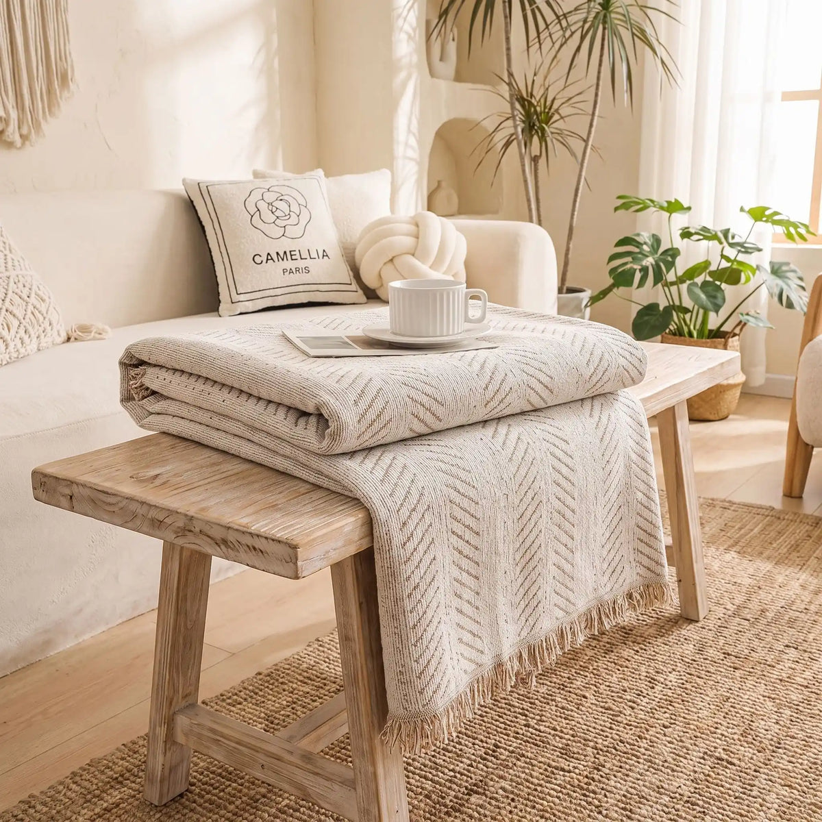 Protection-canapé-chien-bohême-anti-poils-résistante aux griffes, tissage chenille coton et polyester, écoresponsable avec franges pour un style bohème chic de couleur blanc crème dispoinble en 4 tailles pour fauteuil/canapé une place, deux places, 3 places et 4 places, lavable en machine, doux respirant confortable et 4 saisons-gros plan sur le plaid de protection plié disponible en 4 tailles pour s'adapter à tous mobilier, légère, transportable, idéal pour les déplacement et protéger les sièges voiture