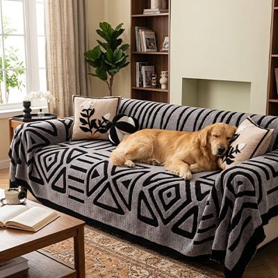 Protection-canape-chien-chiot-plaid chaud et épais, antidérapant et coutures solides, lavable en machine à laver avec design déométrique moderne pour couvrir et protéger le canapé, lit ou mobilier des poils et tâches des chiens, écoresponsable et résistantes aux griffes-un golden retriever qui dort paisiblement sur la protection de couleur gris clair et motif noir sur le canapé 3 places dans le salon de la maison