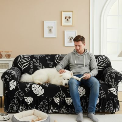 Protection-canape-chien-anti-poils-anti accident, lavable en machine, haute élasticité et resistante aux griffes et à l'usure, universelle en 4 tailles pour fauteuil, canapé de 2/3/4 places, avec élastique et bloque plis- design floral délicat- un maitre assis qui caresse son chien blanc à long poils épais couché confortablement sur le canapé avec sa housse extensible universelle noir dans le salon de l'appartement