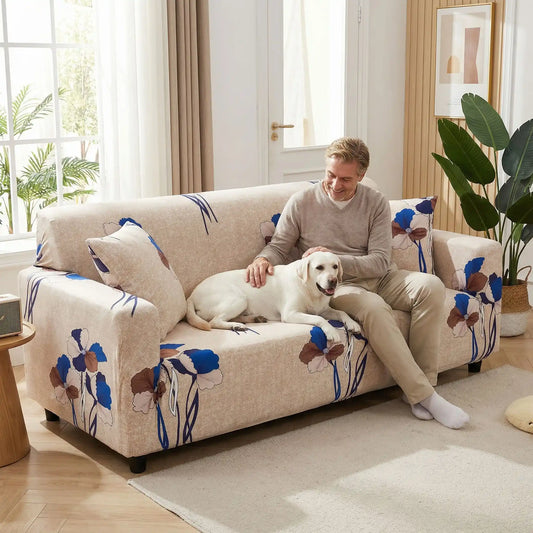 Protection-canape-chien-anti-poils-anti accident, lavable en machine, haute élasticité et resistante aux griffes et à l'usure, universelle en 4 tailles pour fauteuil, canapé de 2/3/4 places, avec élastique et bloque plis- design floral délicat- un maitre assis confortablement sur le canapé qui caressse tendrement son grand chien couché à côté de lui sur le canapé dans le salon de la maison
